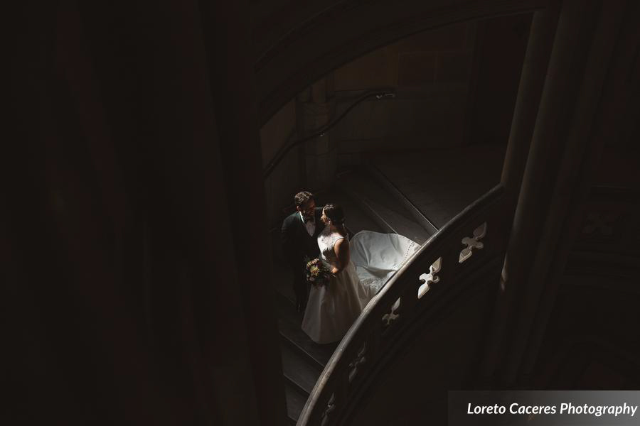 Bride and groom in staircase with a shadow.
