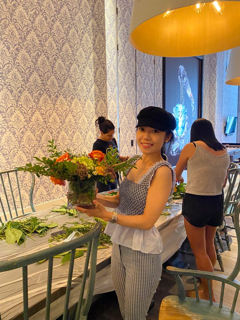 Woman holding a flower arrangement. 