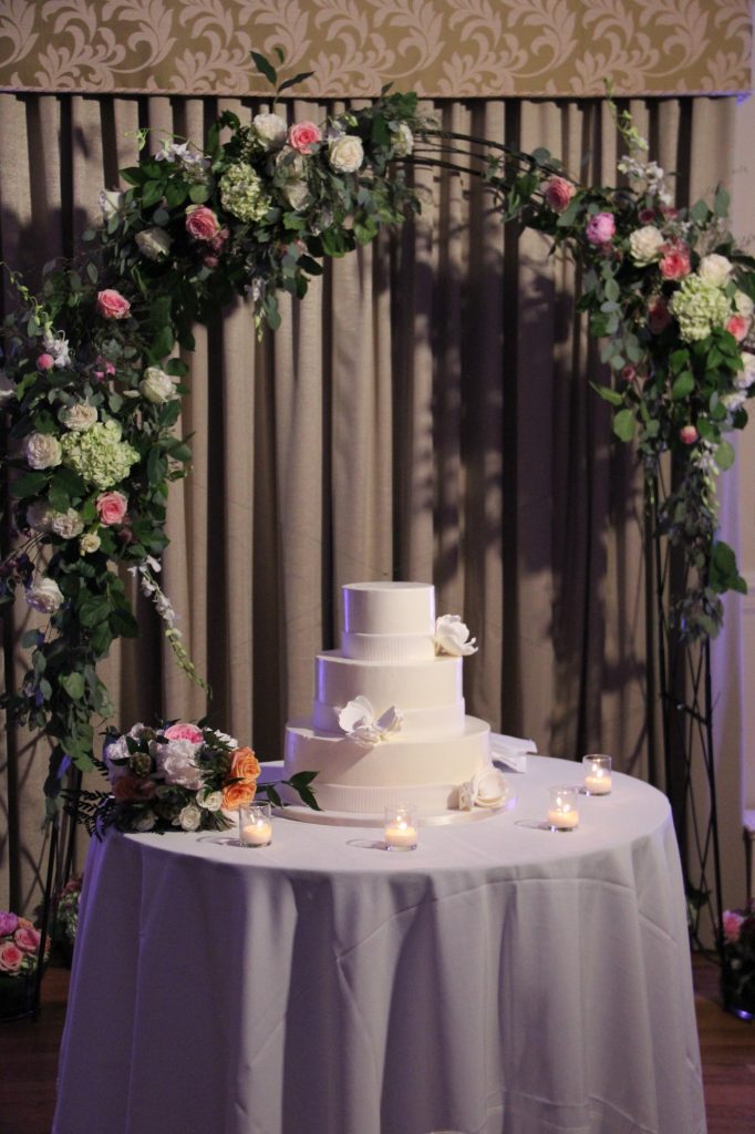 Floral arch with wedding Cake